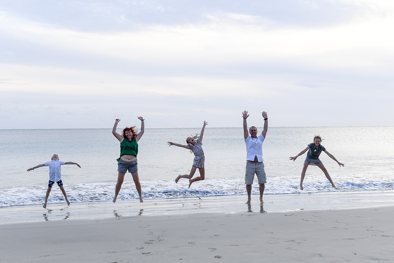 Family jumps in the air on the beach in Natadola Fiji