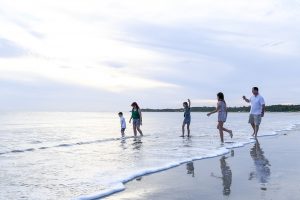 Silhouette photo of family walking in the ocean on Natadola beach Fiji