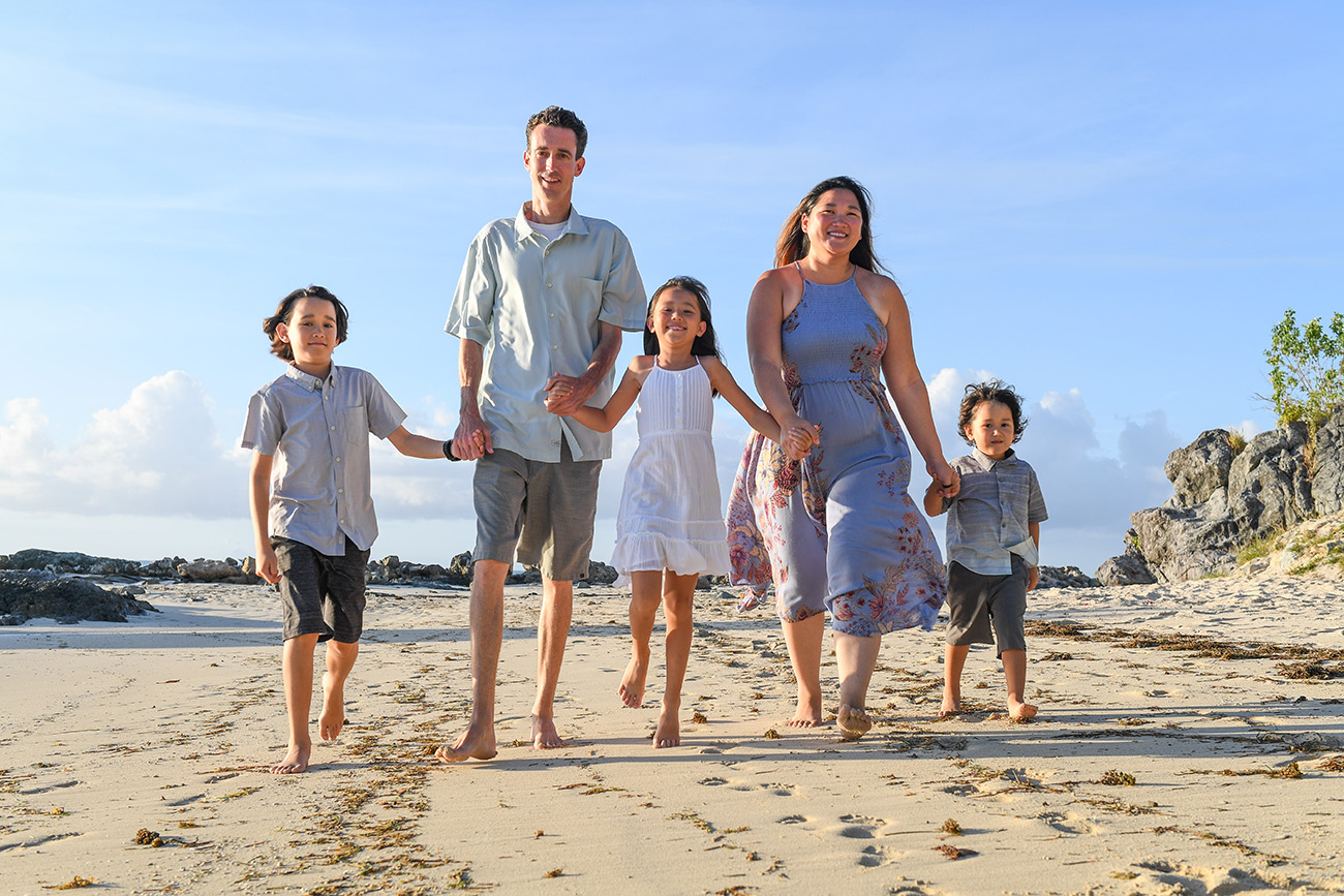 Beautiful family strolling on the beach in family photoshoot