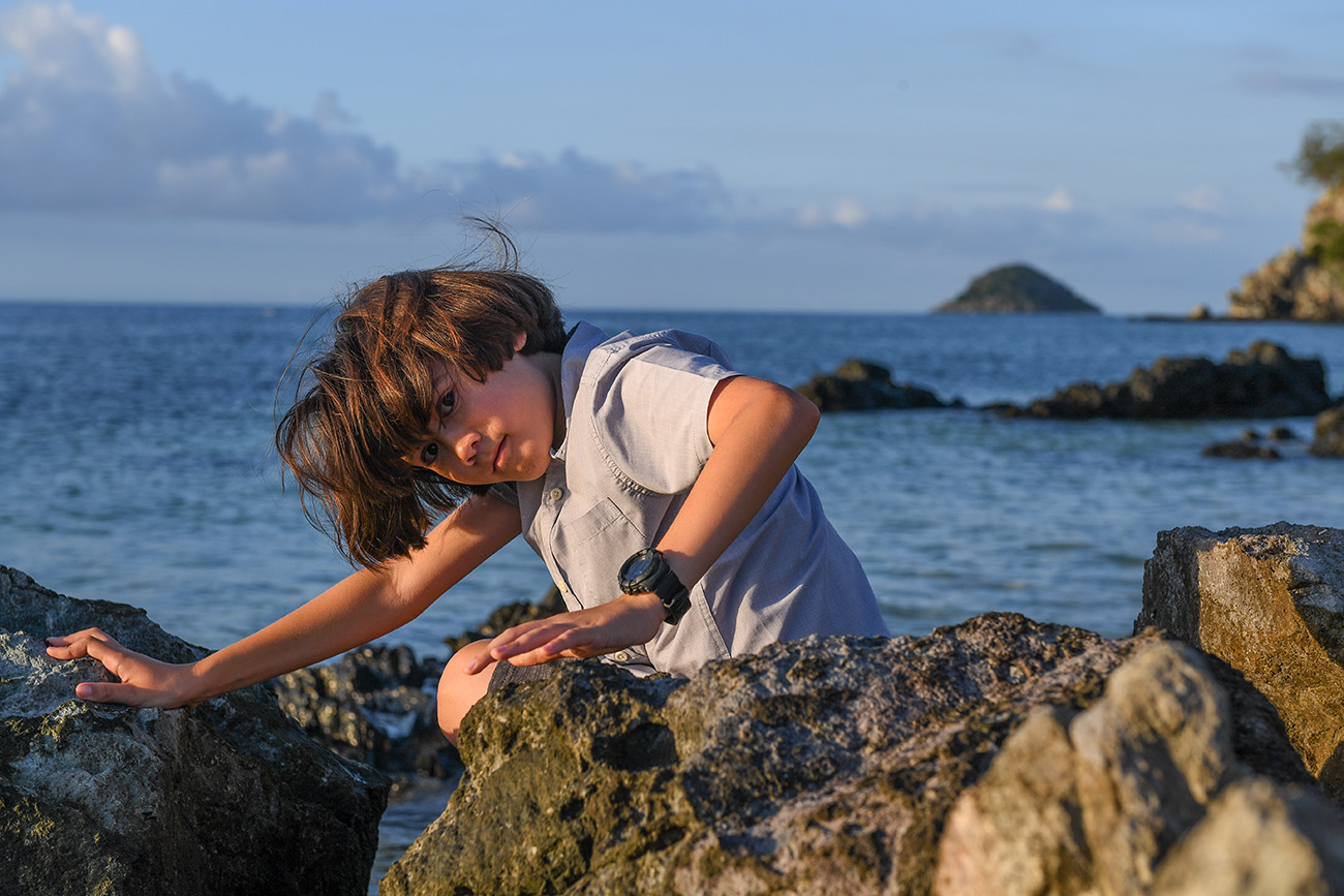 Cute boy makes funny pose against the sea in Malolo Fiji