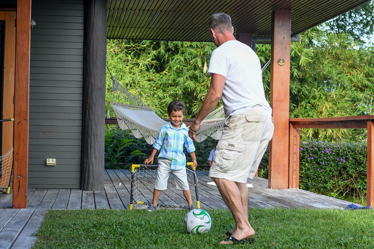 Dad and son play soccer during Fiji family location