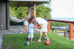 Dad hugs son while playing soccer at Fiji family vacation