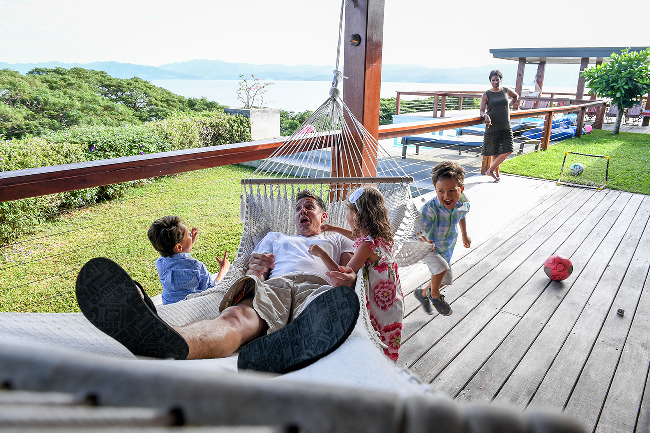 Children swing dad on hammock during Fiji family vacation