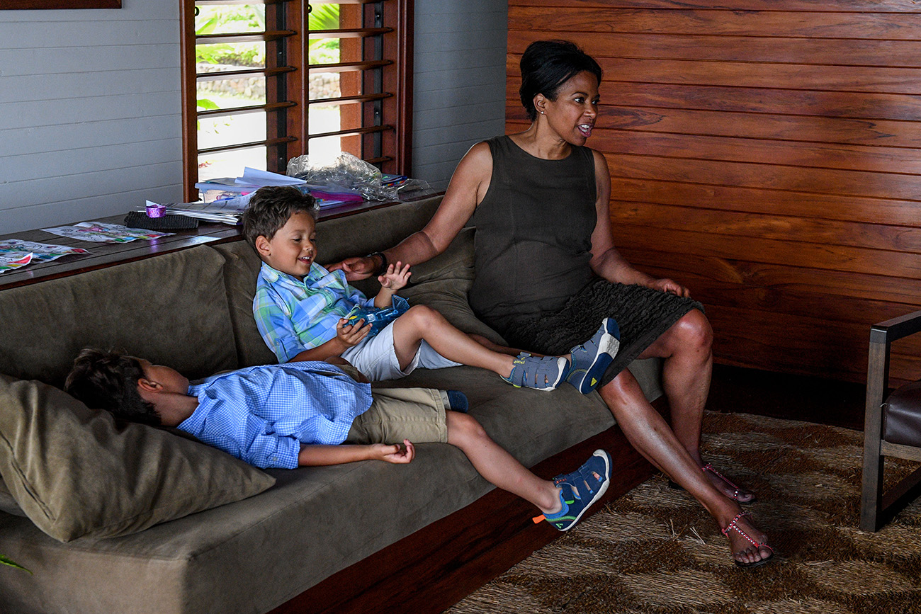 Mom and sons sit on couch in Fiji family vacation