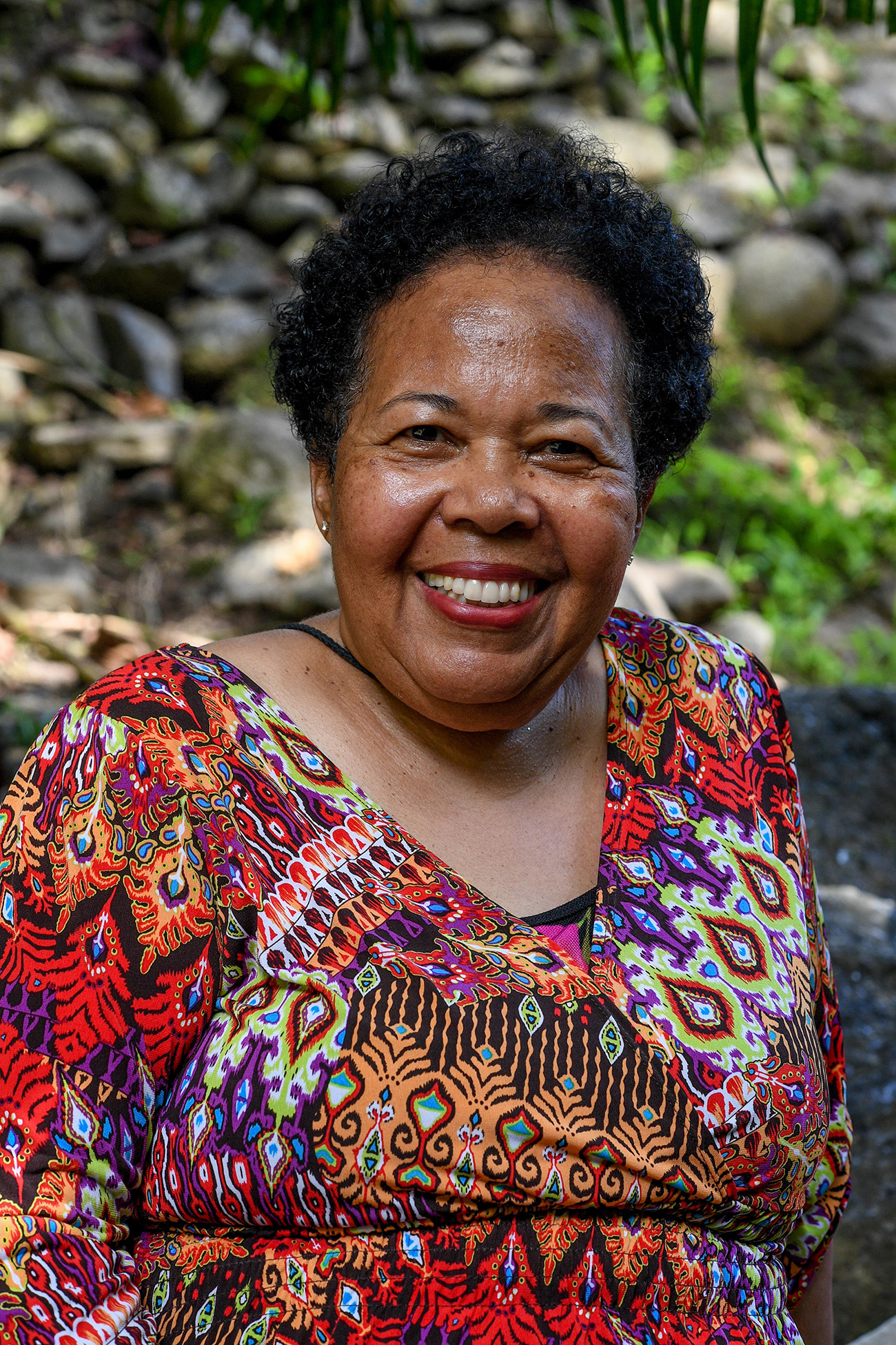 Portrait of polynesian grandma smiles at the camera in family vacation photoshoot
