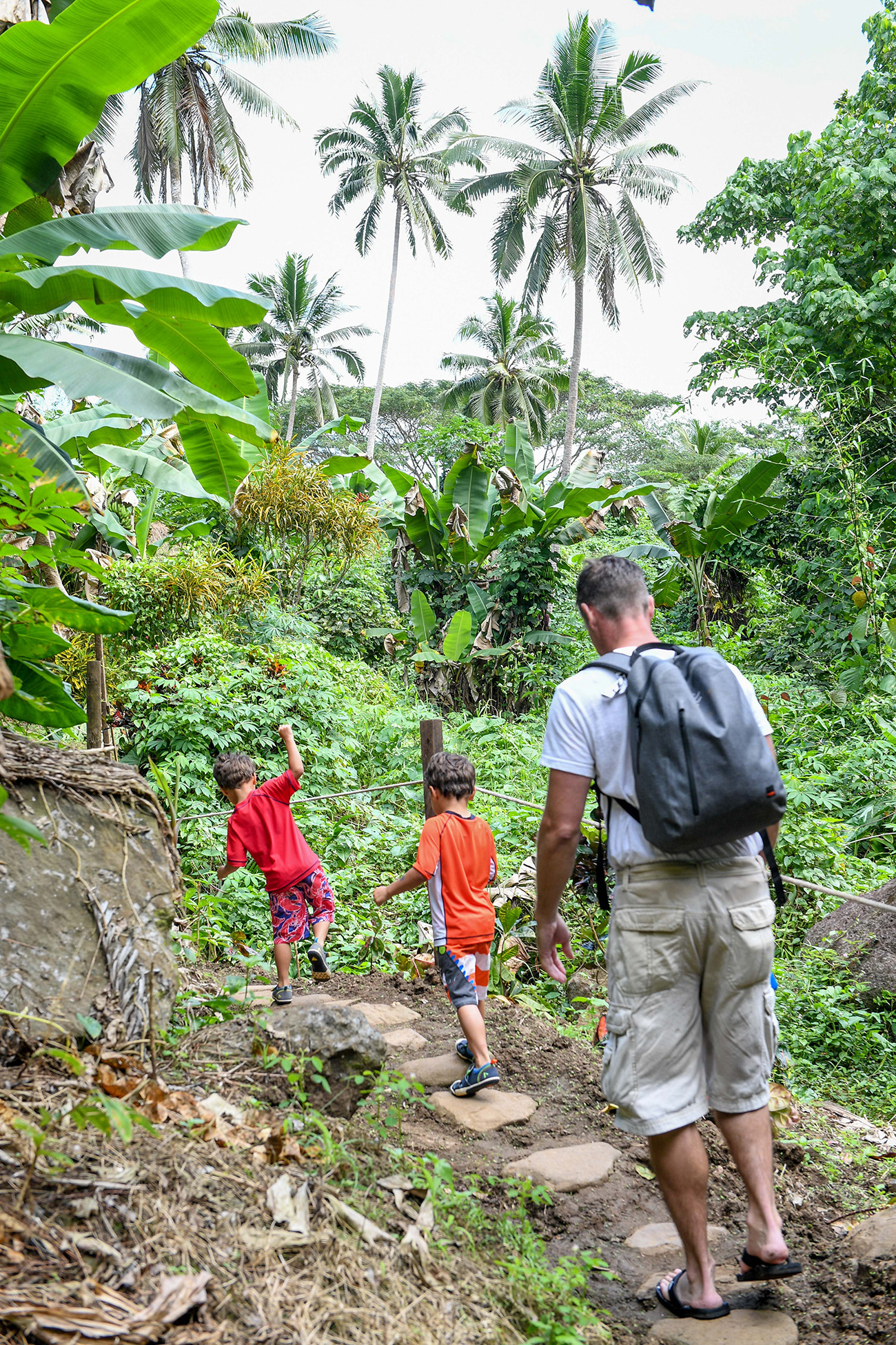 Family walks back through tropical rainforest in Fiji