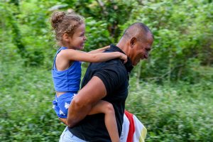 Girl rides piggyback on grandpa in Fiji