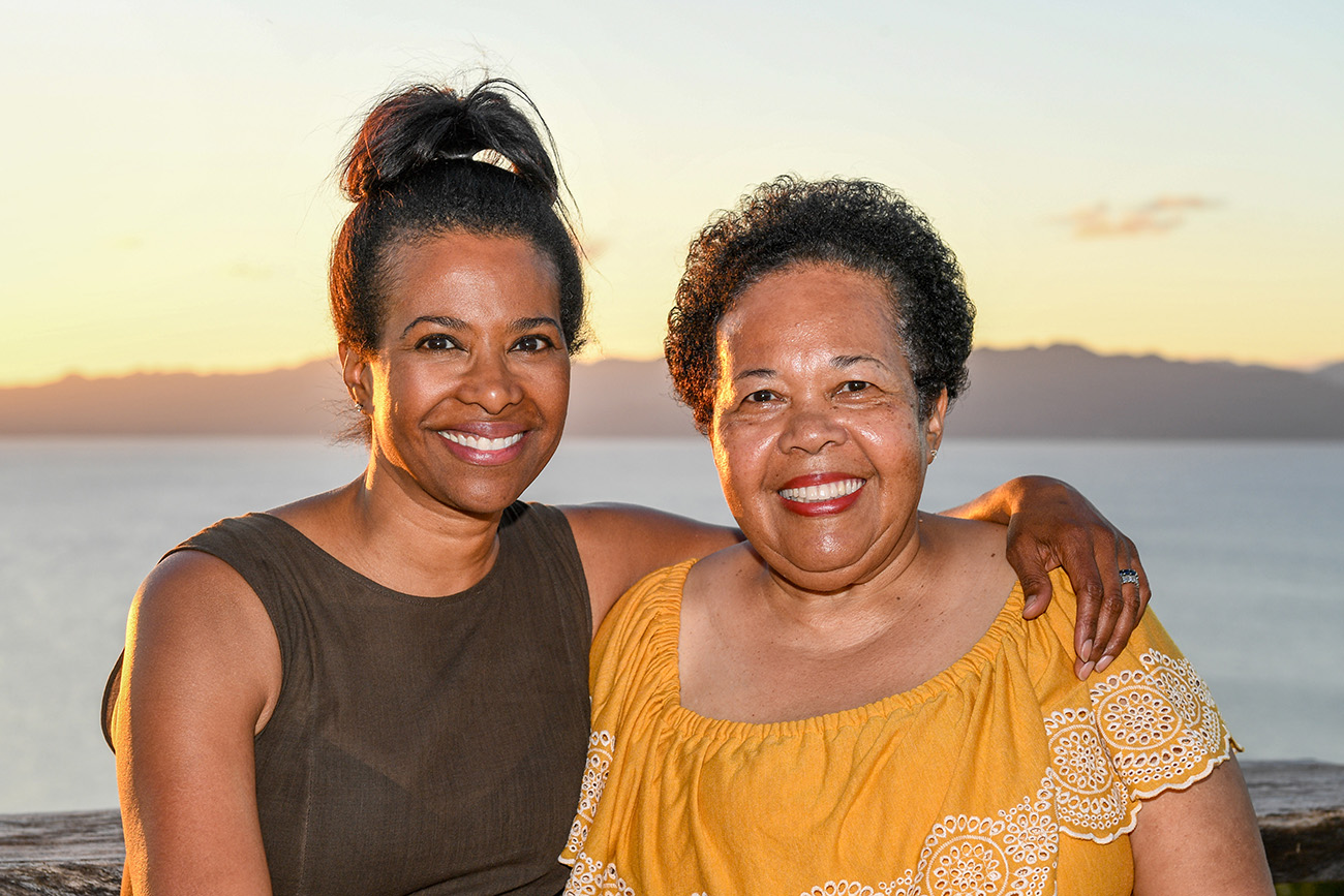 Mom and daughter hug against sunset in Fiji