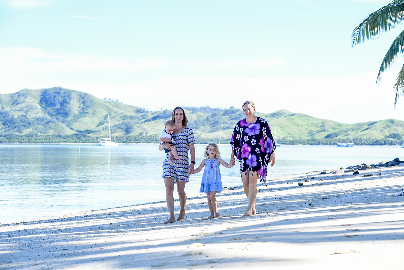 same-sex family strolling down the beach at Plantation Island Resort