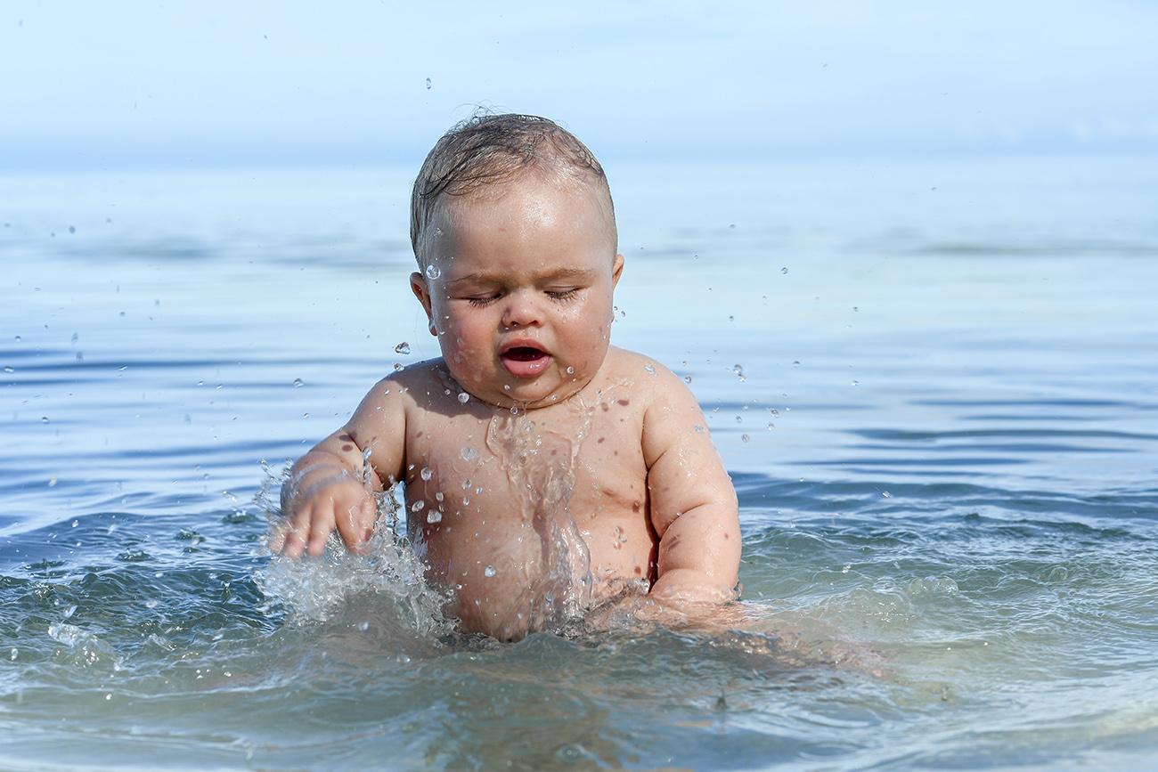 Gorgeous infant playing in the ocean