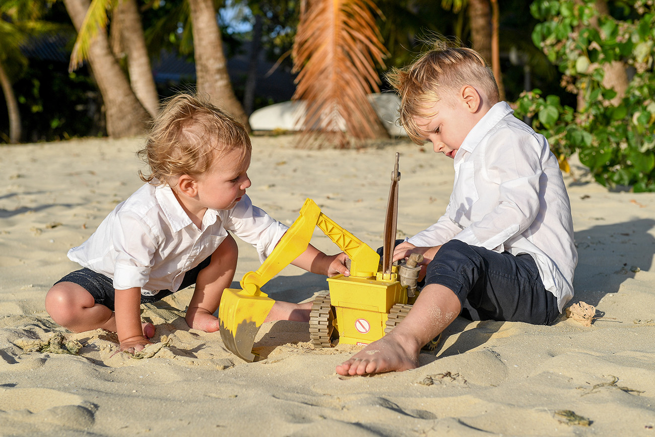 Siblings build sand castles in the sand