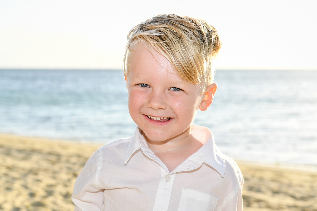 blond green-eyed boy in the sand