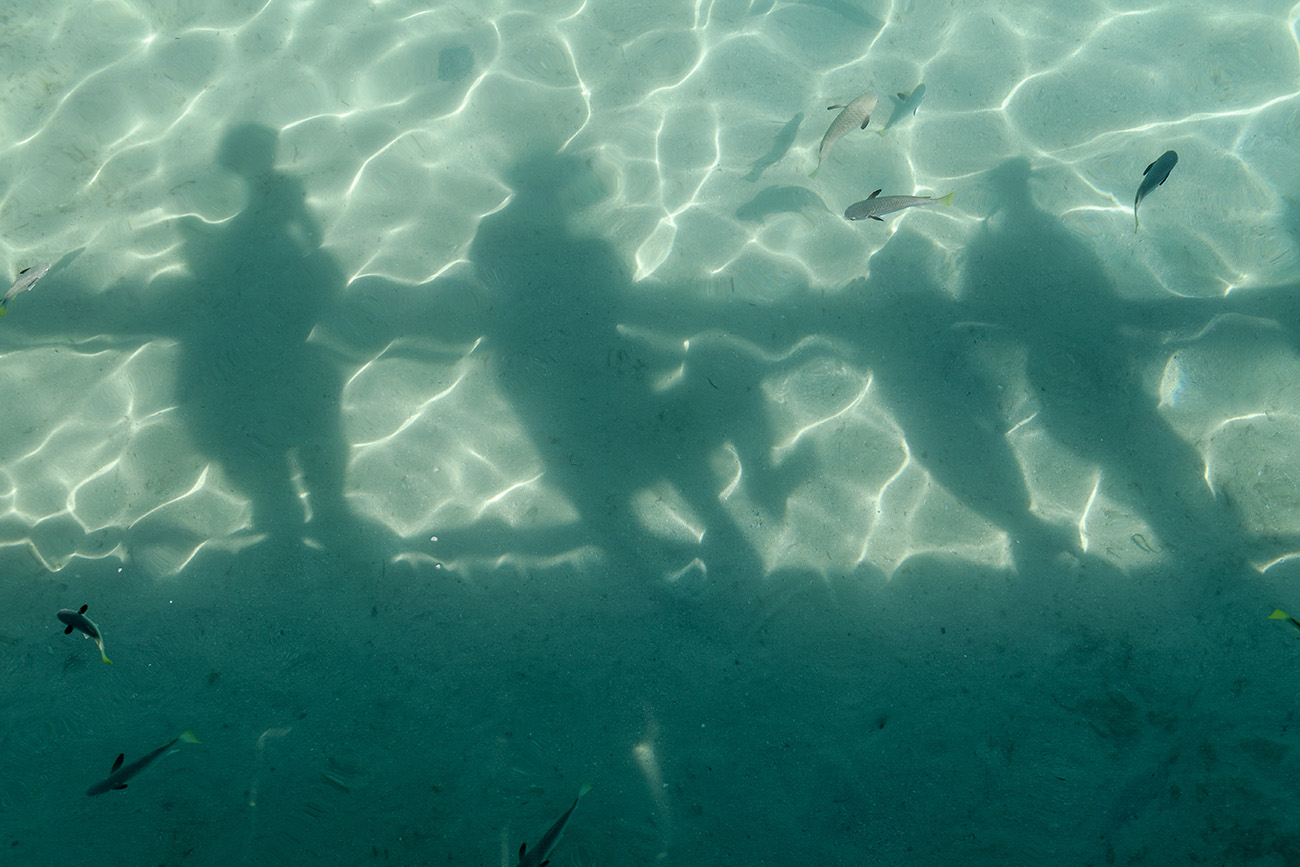 The family creates shadows into the clear waters at Plantation Island Resort
