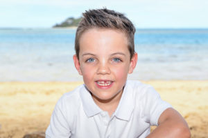 The cute blue eyed boy on the sunny beach at Malolo Island