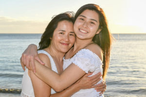 Mother hugs daughter against Fiji sunset