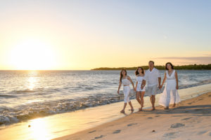 The family strolls beside the golden Fiji sunset