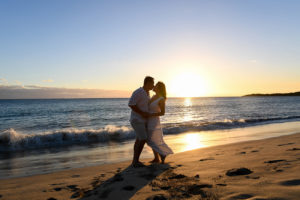 An asian couple kisses against the sunset