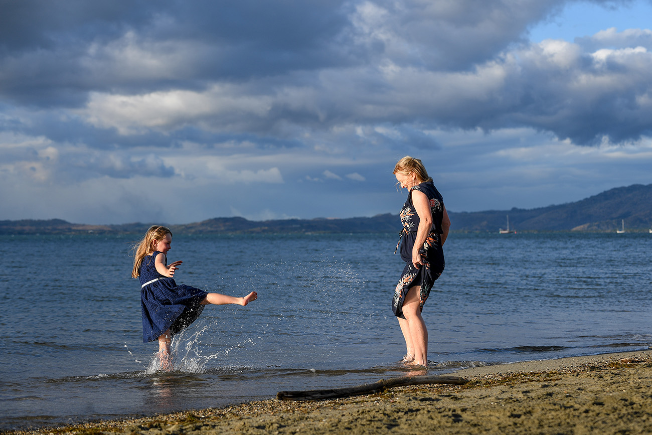 A girl kicks water at her mother at the beach at Denarau Fiji