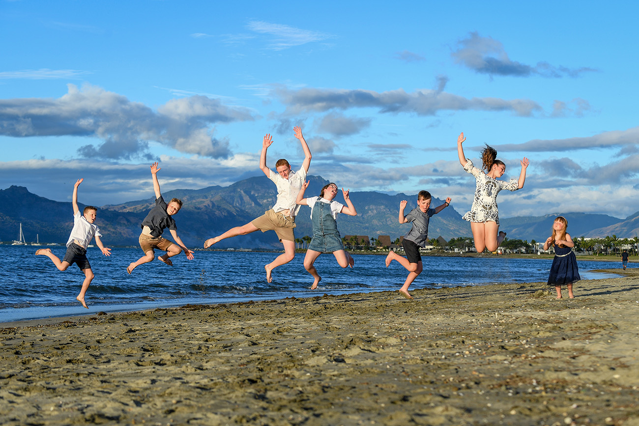Kids to a frog leap in the air over the beach at Denarau Fiji