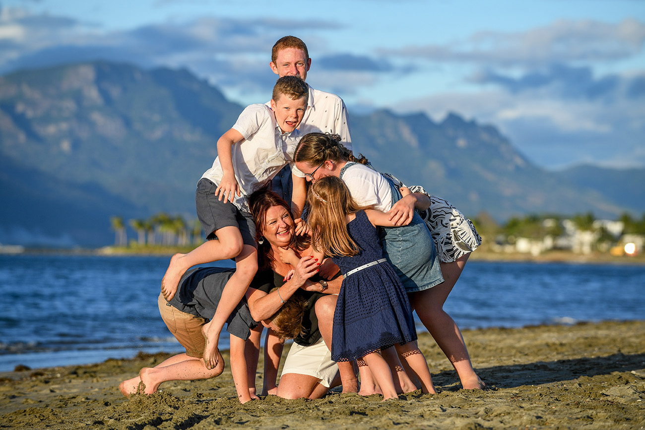 Kids climb over their mother at the beach