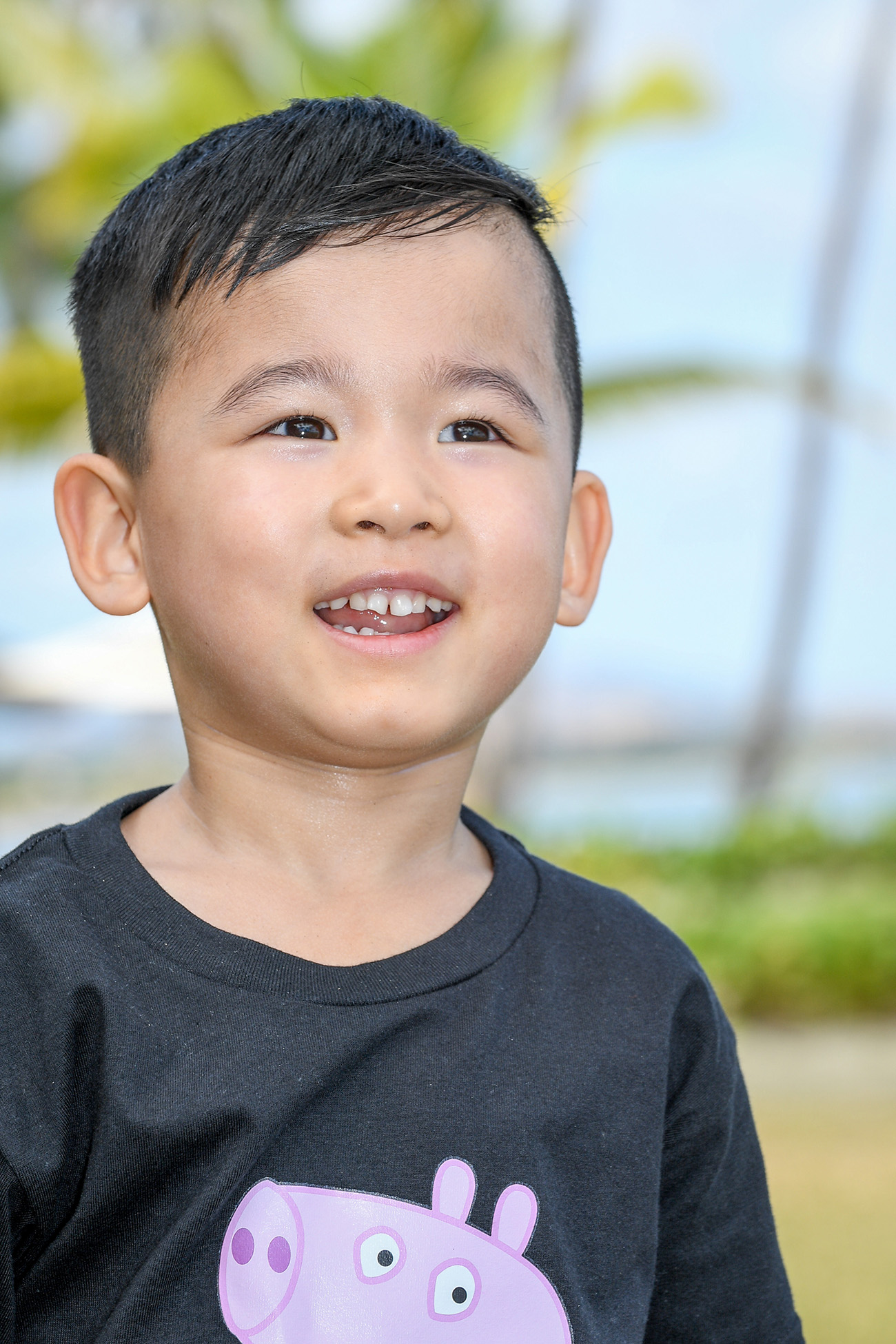 Cute asian boy on the beach against baby blue skies