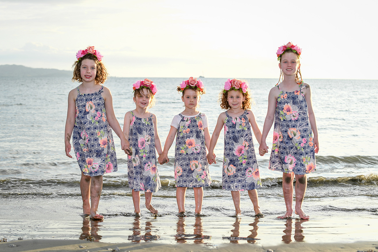 Cousins in matching outfits and flower crown walk on the Natadola beach at Denarau Fiji