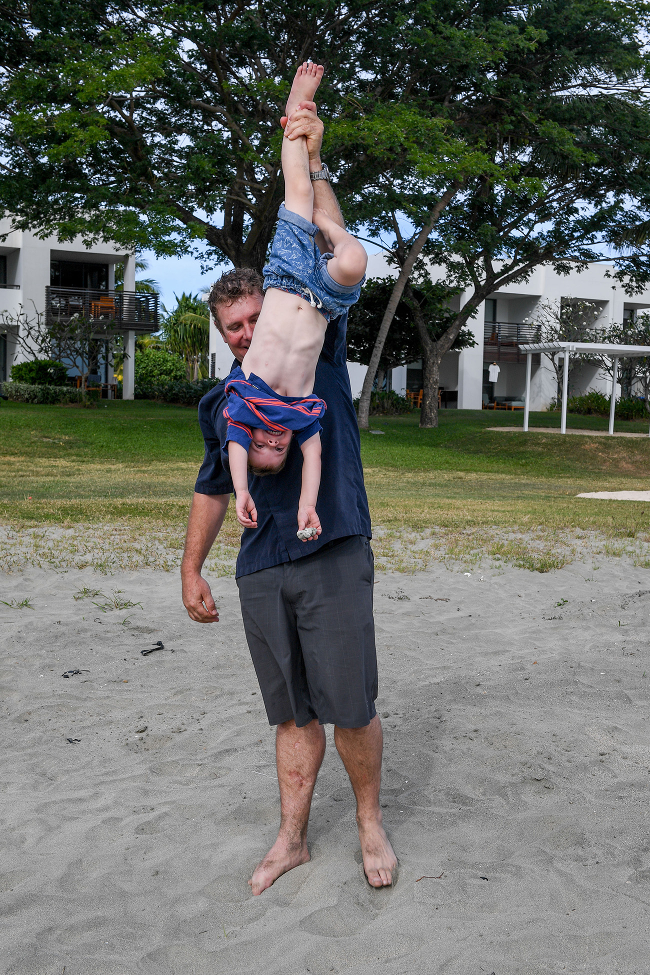 A father carries his son upside down