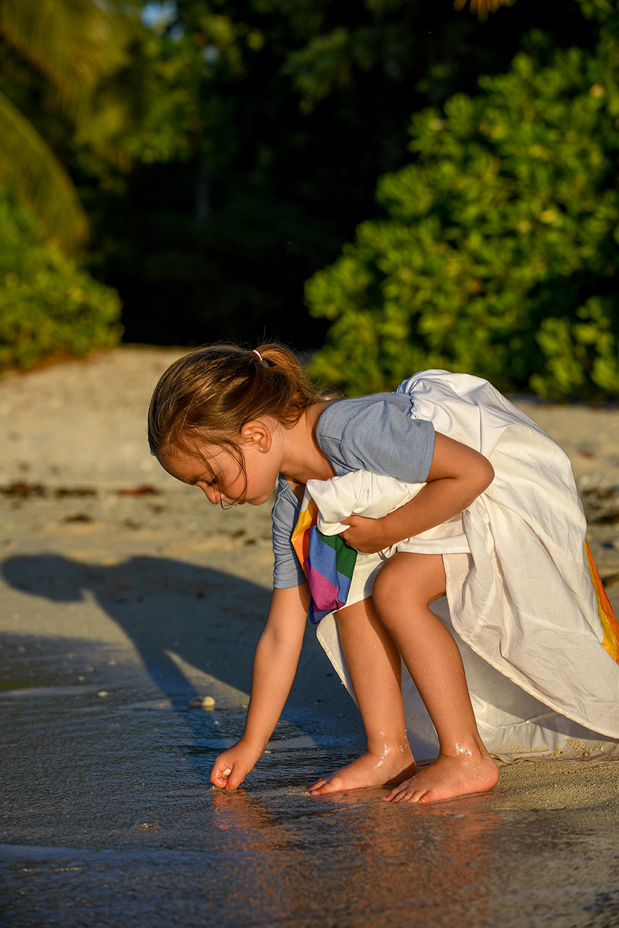 Young girl draws in the sand on the beach