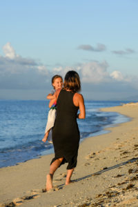 Mother and daughter play on the beach