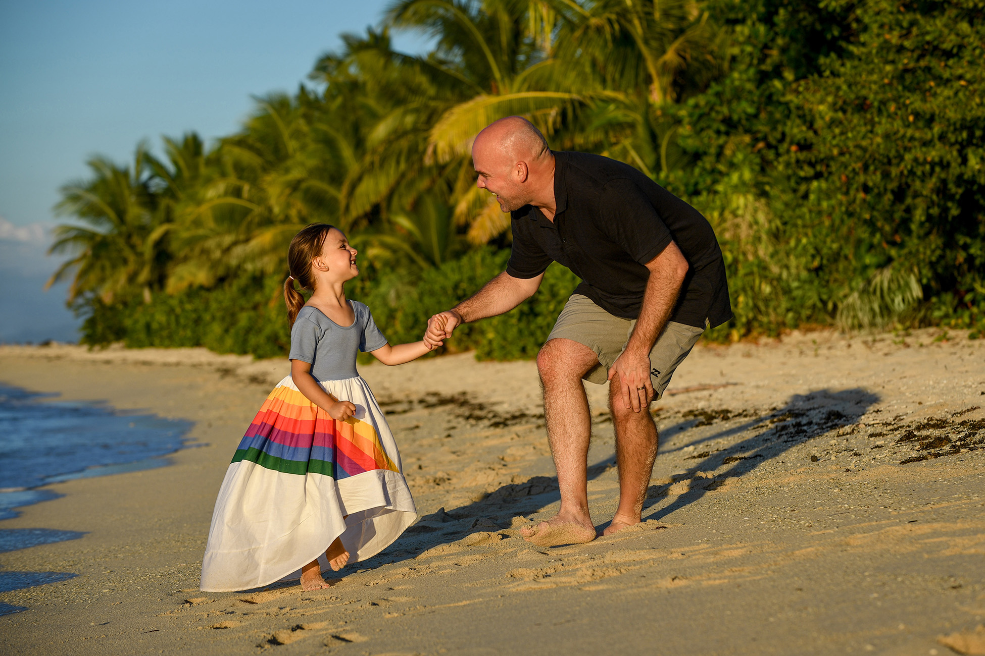 Father and daughter play games on the beach