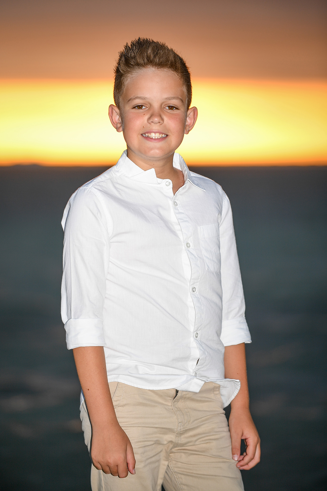 Portrait of a boy standing at the beach at sunset in Fiji