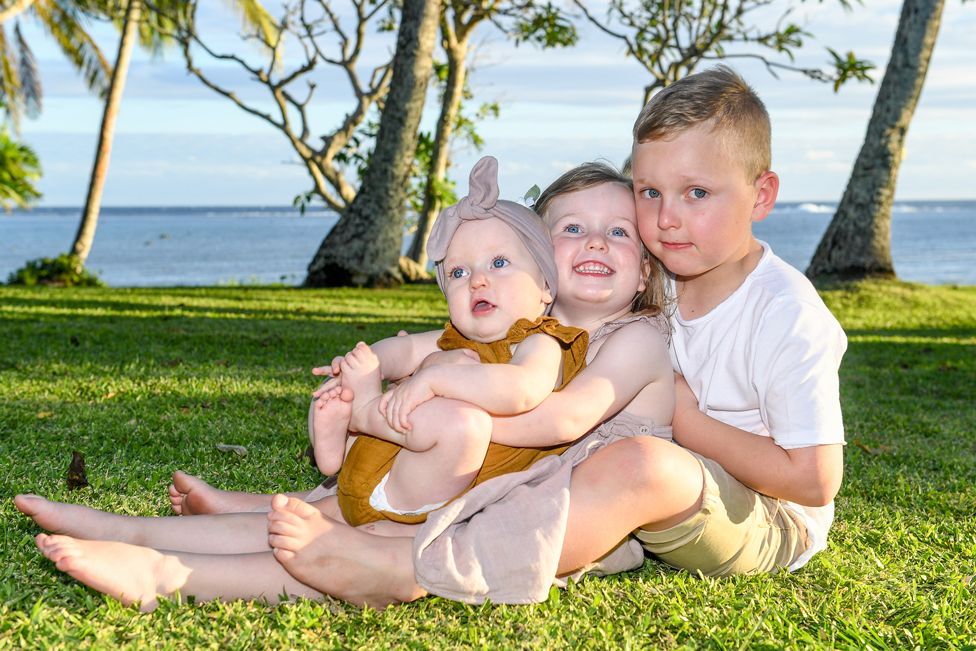 Portrait of siblings sitting on the lawn of the Shangri in Fiji