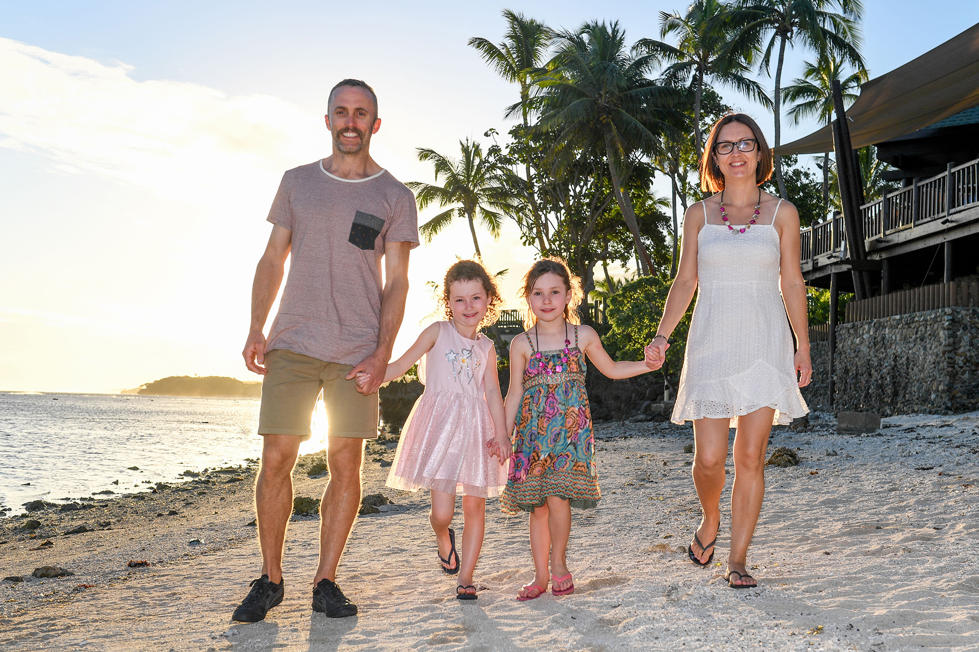 Family walking holding hands on the beach in Fiji