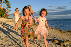 Family running and racing on the beach for a fun photshoot