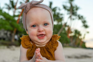 Portrait of a baby with beach and palm trees in the background